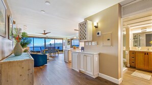 A spacious living area with a large window overlooking a scenic view, a dining area with a view, and a kitchen with modern cabinetry.
