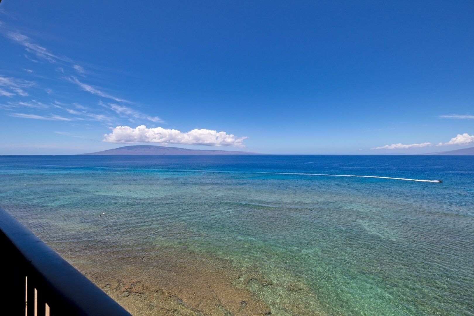 Una spiaggia tropicale con acque poco profonde e una montagna in lontananza.