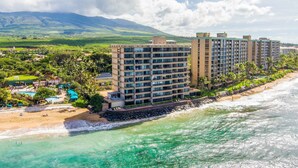 A beachfront hotel with multiple high-rise buildings, a sandy beach, and a clear view of the ocean.