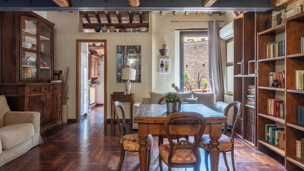 Un comedor acogedor con muebles de madera, una estantería y vistas al exterior.