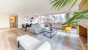 Un salon moderne avec un canapé, une table basse et un coin repas.