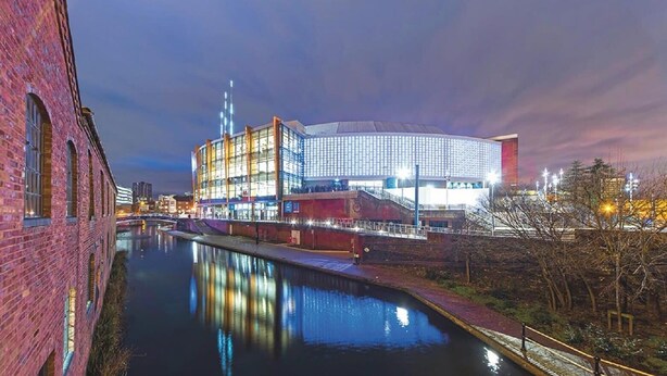A modern building with a glass facade and a reflection in the water. - Large Home near Edgbaston Stadium, UOB & QE hospital sleeps 6 (Birmingham)