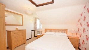 Un dormitorio con una cama grande, un aparador de madera y un espejo.