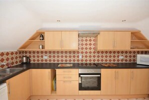 Kitchen features an oven, microwave, and diamond-patterned tile backsplash.