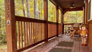 Eine Holzveranda mit Blick auf Herbstbäume.
