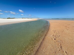 A beach with clear shallow water and a sandy shore. - Sunrise Showcase - Serene direct river view! (St. Augustine)