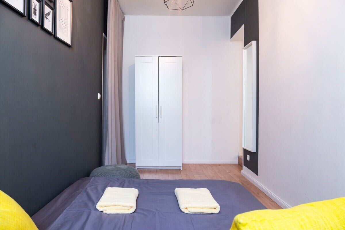 Un dormitorio con cama, dos toallas, un armario y una puerta.
