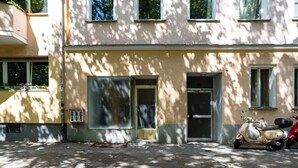 A building with a flat facade, large windows, and a parked scooter. - 2-Bedroom-Apartment in Berlin-Kreuzberg (Berlin)