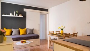 A modern, compact living space with a sofa, dining table, and a small white cabinet. - 2-Bedroom-Apartment in Berlin-Kreuzberg (Berlin)