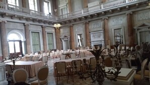 A grand hall with high ceilings, ornate columns, and a checkered floor. Tables and chairs are arranged for dining. - Charming Wentworth Lodge With Countryside Views (Rotherham)
