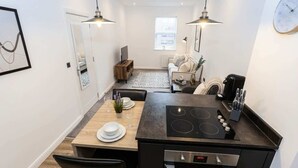 Una cocina compacta con comedor, horno integrado y cafetera.