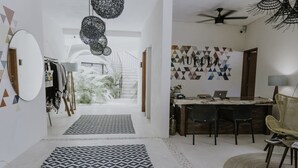 Un interior moderno con comedor, escalera y vista a un jardín.