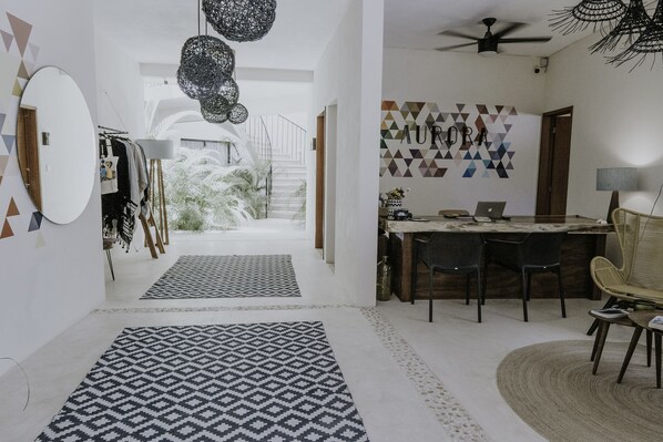 A modern interior with a dining area, a staircase, and a view of a garden.