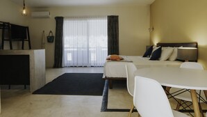 Una habitación de hotel con cama, escritorio y zona de comedor.