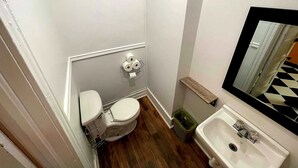 A small bathroom with a toilet, sink, and mirror.