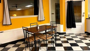A dining area with a checkered floor, a wooden table, and chairs.