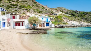 A coastal building with a sandy beach and clear waters. - ECO SIRMA FLARIS (Milos)