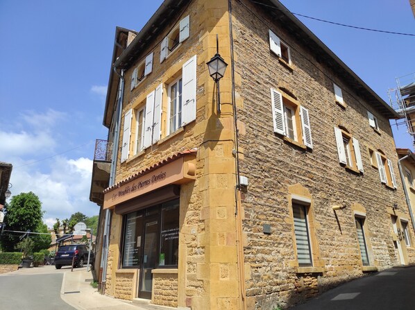 A stone building with a storefront labeled "Les Moulins des Pierres Dorées".