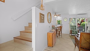 Una escalera conduce a un comedor con vista a un jardín.