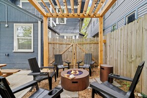 A backyard with a pergola, outdoor seating, and a fire pit. - Midtown Getaway: Walk to KC Streetcar-Dining/Entertainment + Fire Pit! (Kansas City)