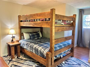 A bunk bed with a wooden frame and plaid bedding. - Riverside Cabin w/Fishing, Hot Tub & Firepit (COSBY)