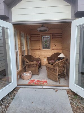 Relax in a serene space with a sauna or steam room, featuring two comfortable chairs and a small table.