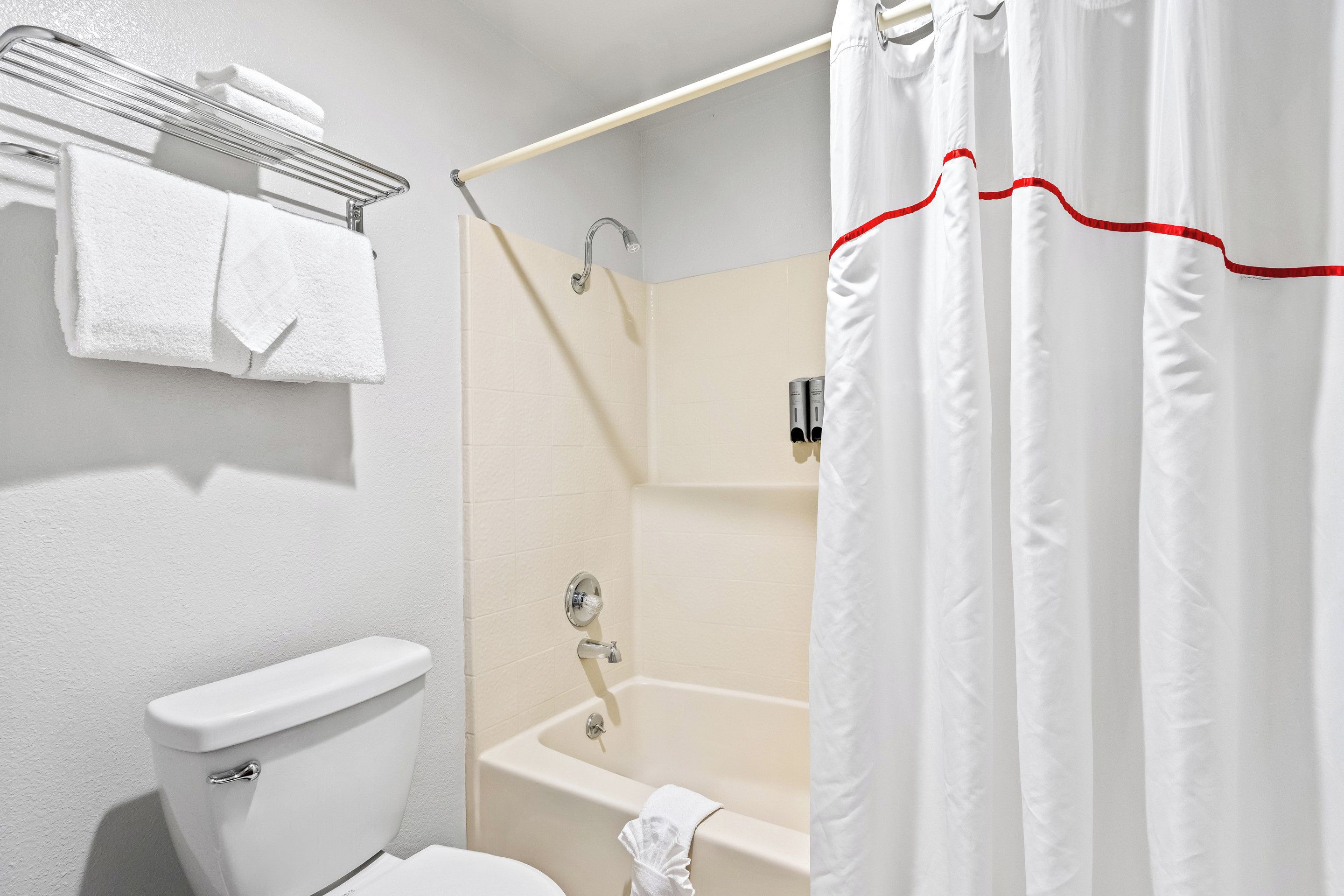 A bathroom with a toilet, a shower with a glass door, and a bathtub.
