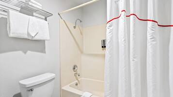 A bathroom with a toilet, a shower with a glass door, and a bathtub.
