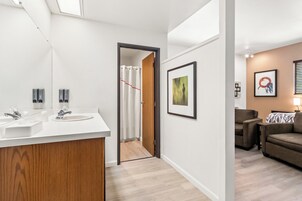 Un baño moderno con lavamanos dobles, ducha y tocador de madera.