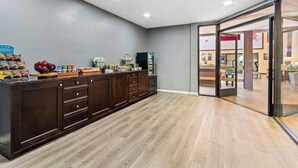 A modern kitchen with a wooden countertop, built-in cabinets, and a view into the dining area.