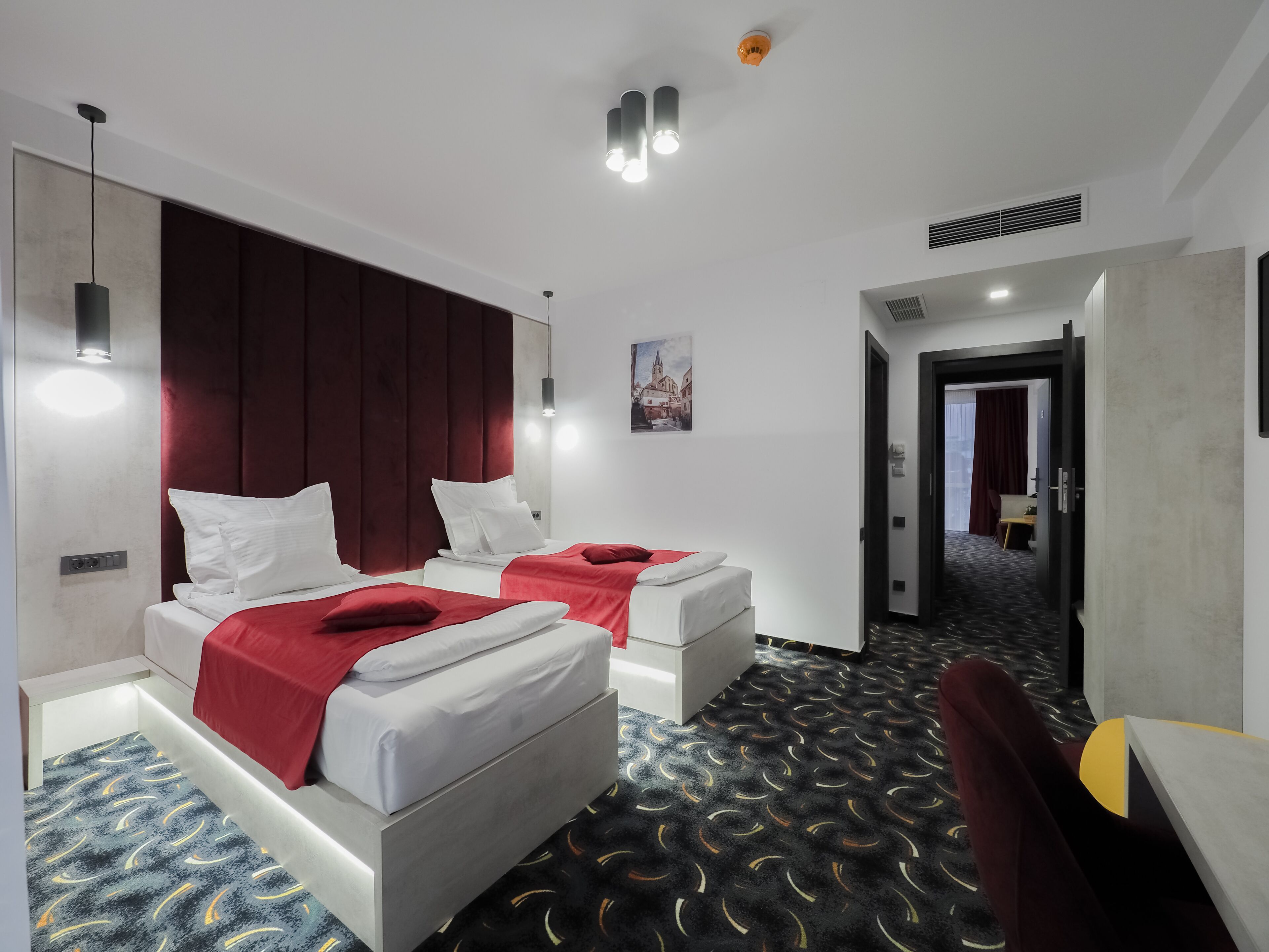 Ein Hotelzimmer mit zwei Betten, einem Schreibtisch und einem Stuhl.