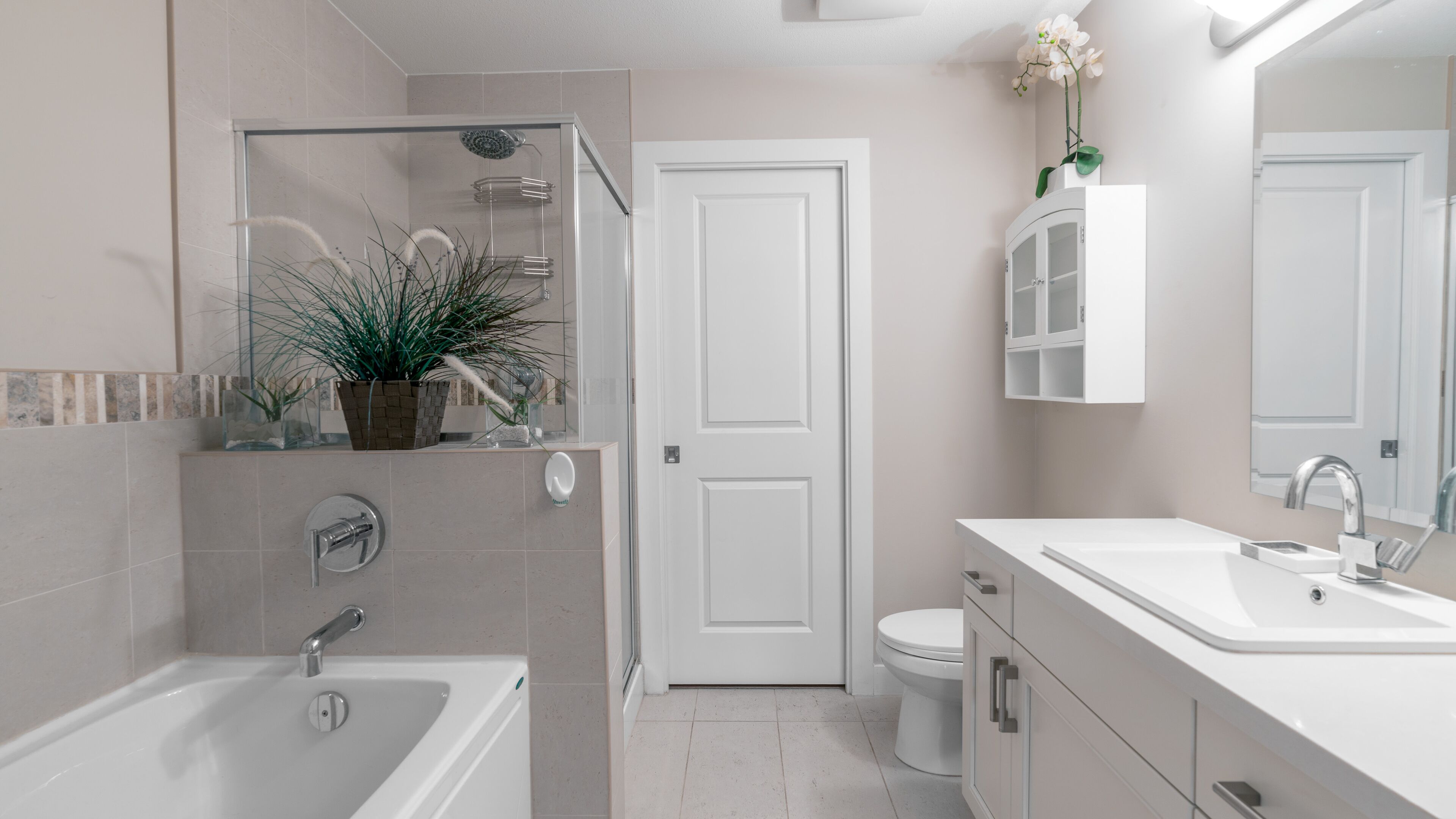 A modern bathroom with a bathtub, shower, toilet, and vanity.