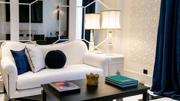 Junior suite | Woonruimte | Een 80-inch smart-tv met digitale zenders en een televisie