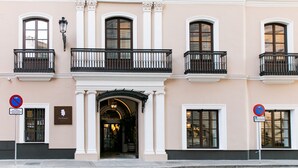A building with a classical facade, featuring arched windows and a central entrance with an ornate archway. - Hotel Casa Palacio Don Ramón 5* GL by Kaizen Hoteles (Seville)