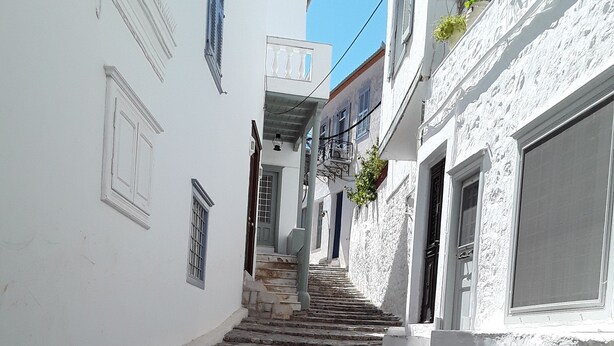 A narrow stone staircase leading up to a building with white walls and balconies. - Π αραδοσιακο σπιτι στην καρδια της Υδρας (Hydra island, Saronic Gulf)