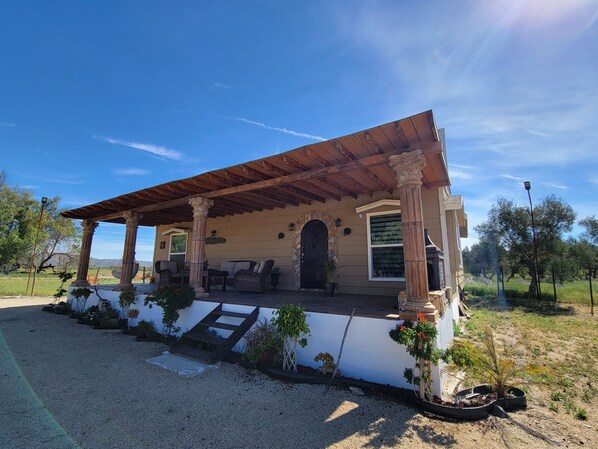 A house with a covered porch, stone columns, and a stone entrance.