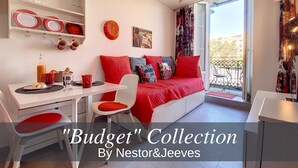 A modern, compact living space with a dining area, a sofa bed, and a balcony with a view.
