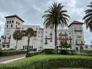 Um edifício grande e histórico com várias varandas e uma palmeira central.