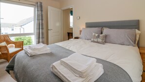 A bedroom with a bed, a chair, and a view of the outside. - 10 Goodhope Gardens (Aberdeen)