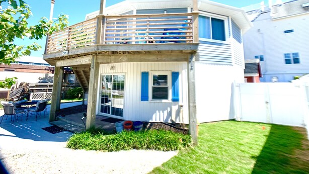 A two-story house with a balcony, a covered patio, and a small garden area. - ❤️Amazing Round House - Easy Self Check-In, Just Steps to Beach! (Carolina Beach)