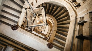 Una escalera en espiral con estructura de soporte metálica y una plataforma circular de observación.