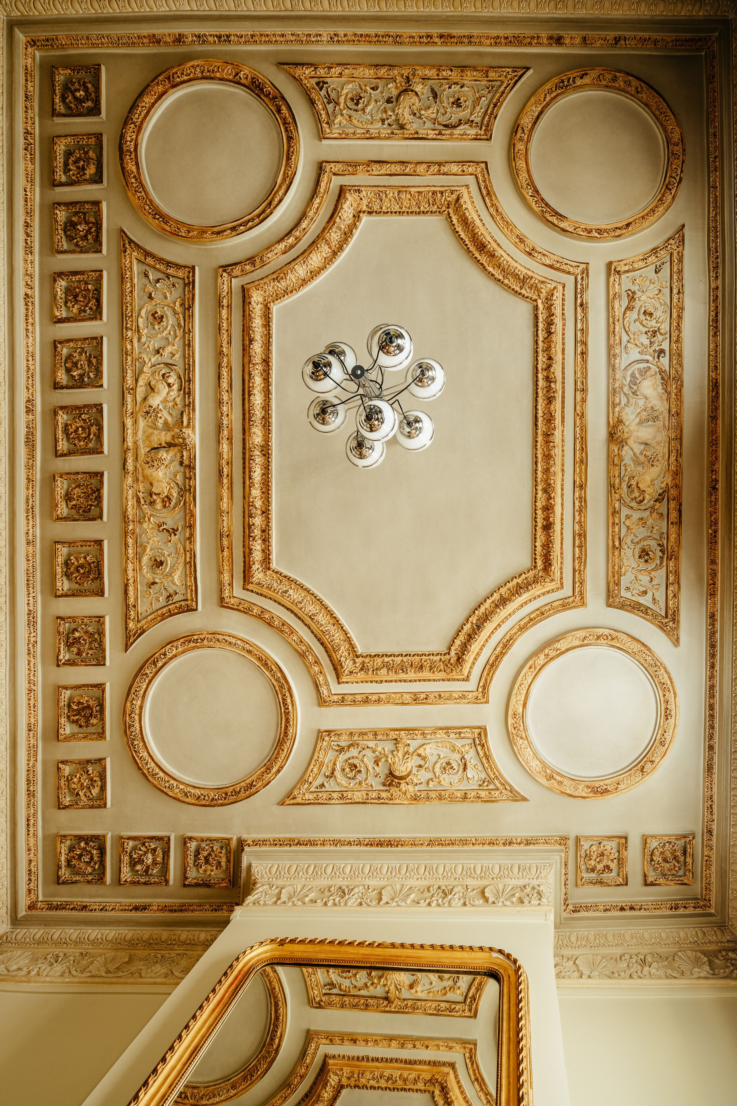 Un sostre amb detalls daurats ornamentals i motius circulars.