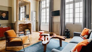 Una sala de estar con chimenea, un sofá, una mesa de centro y un televisor.
