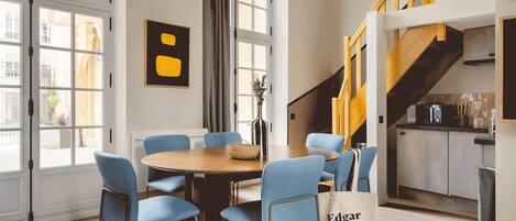 Ein modernes Hotelzimmer mit Essbereich, einer Treppe und Blick auf die Stadt.