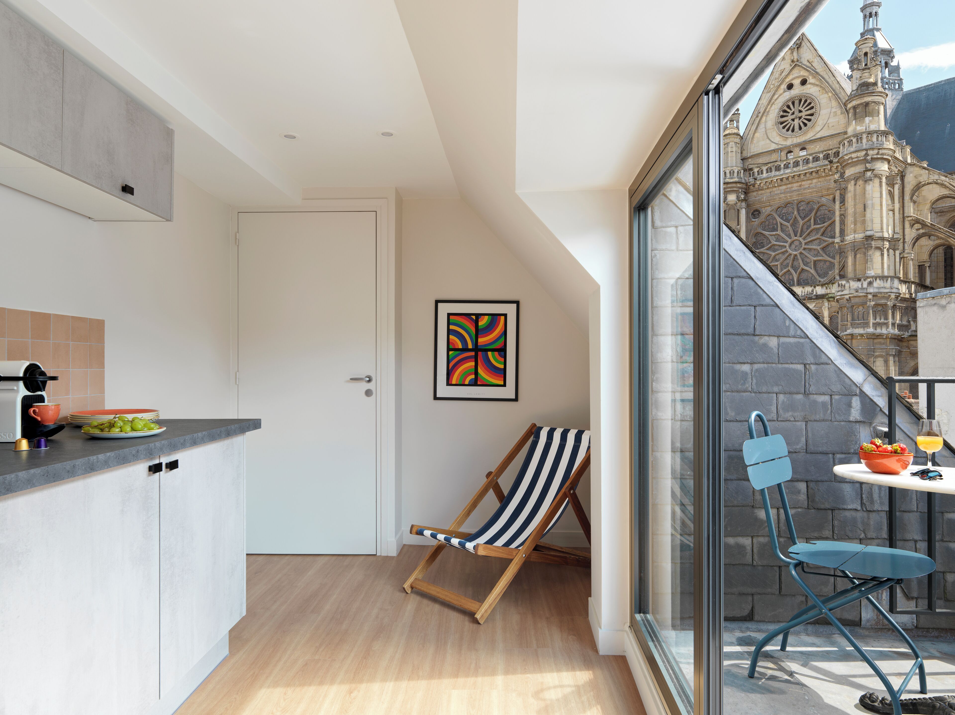 A modern kitchen with a view of a historic building through a glass door.