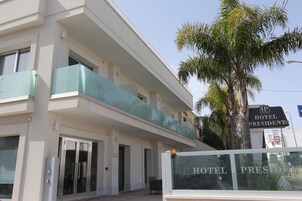 Un hotel con una fachada moderna, un balcón de cristal y un cartel que indica que es el Hotel President.