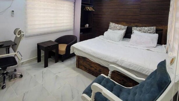 Ein Schlafzimmer mit Bett, Schreibtisch, Stuhl und Kleiderschrank.