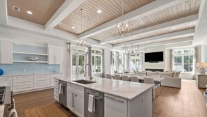 A spacious kitchen with a large island, white cabinetry, and a wooden ceiling. - Casa al Mare|Easy Beach Access|Private Pool|Golf Cart (Seagrove)