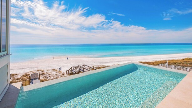 Une piscine avec vue sur une plage et l’océan.