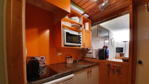 Una cocina compacta con microondas, tostadora y pileta.